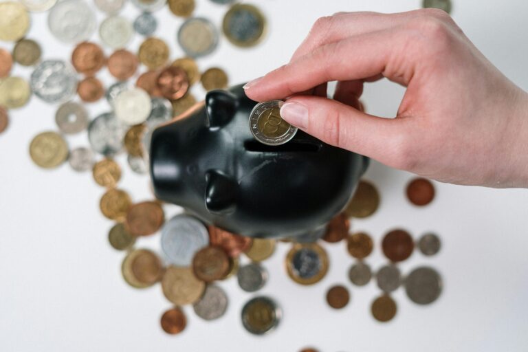 saving money in your 20s Young Indian man holding a pink piggy bank, symbolizing relatable savings habits